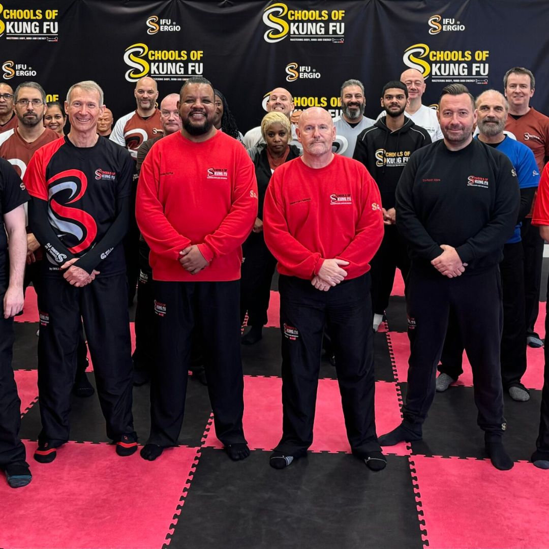 Sifu Kul & Sifu Alan with many students standing for a photo